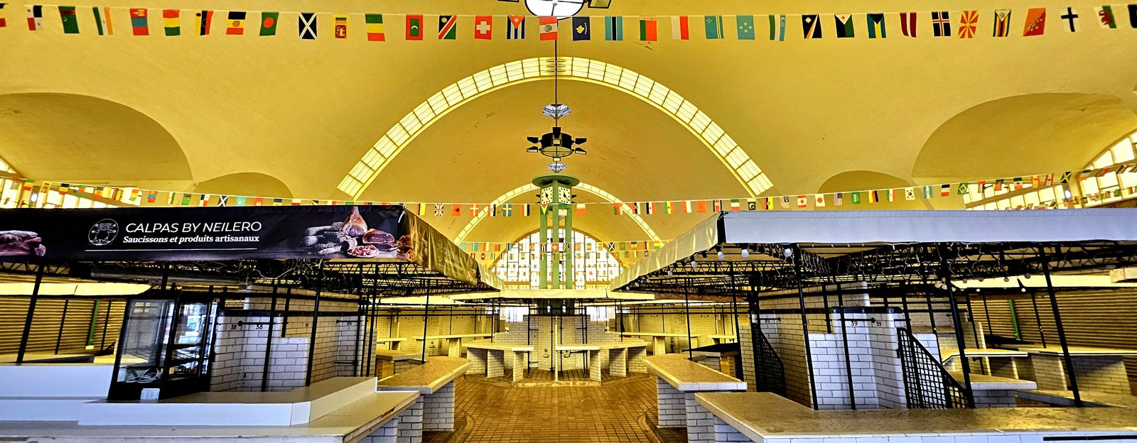 Puestos de mercado bajo la estructura luminosa de un mercado en Rouen.